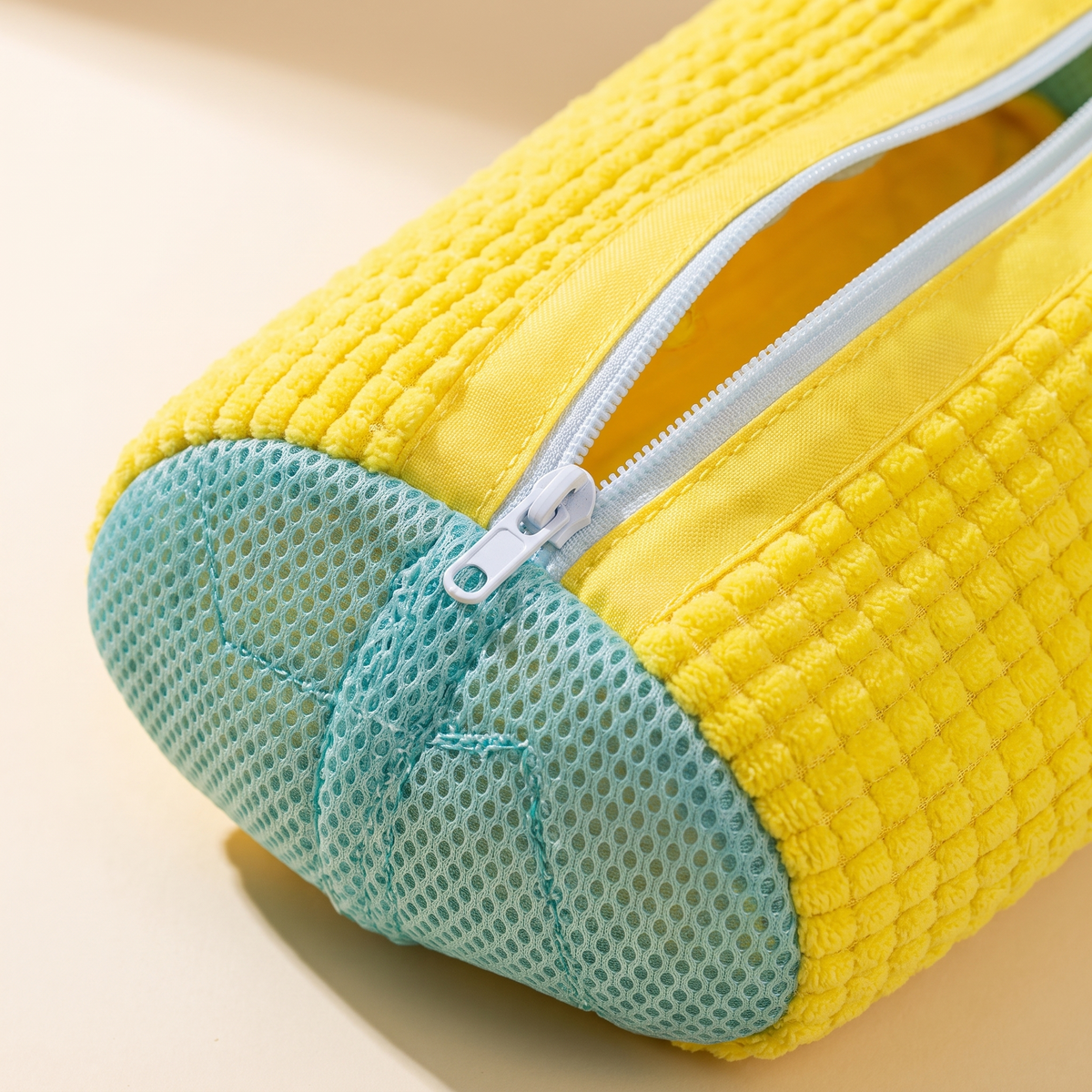 Close-up detail of the yellow sneaker wash bag zipper and material
